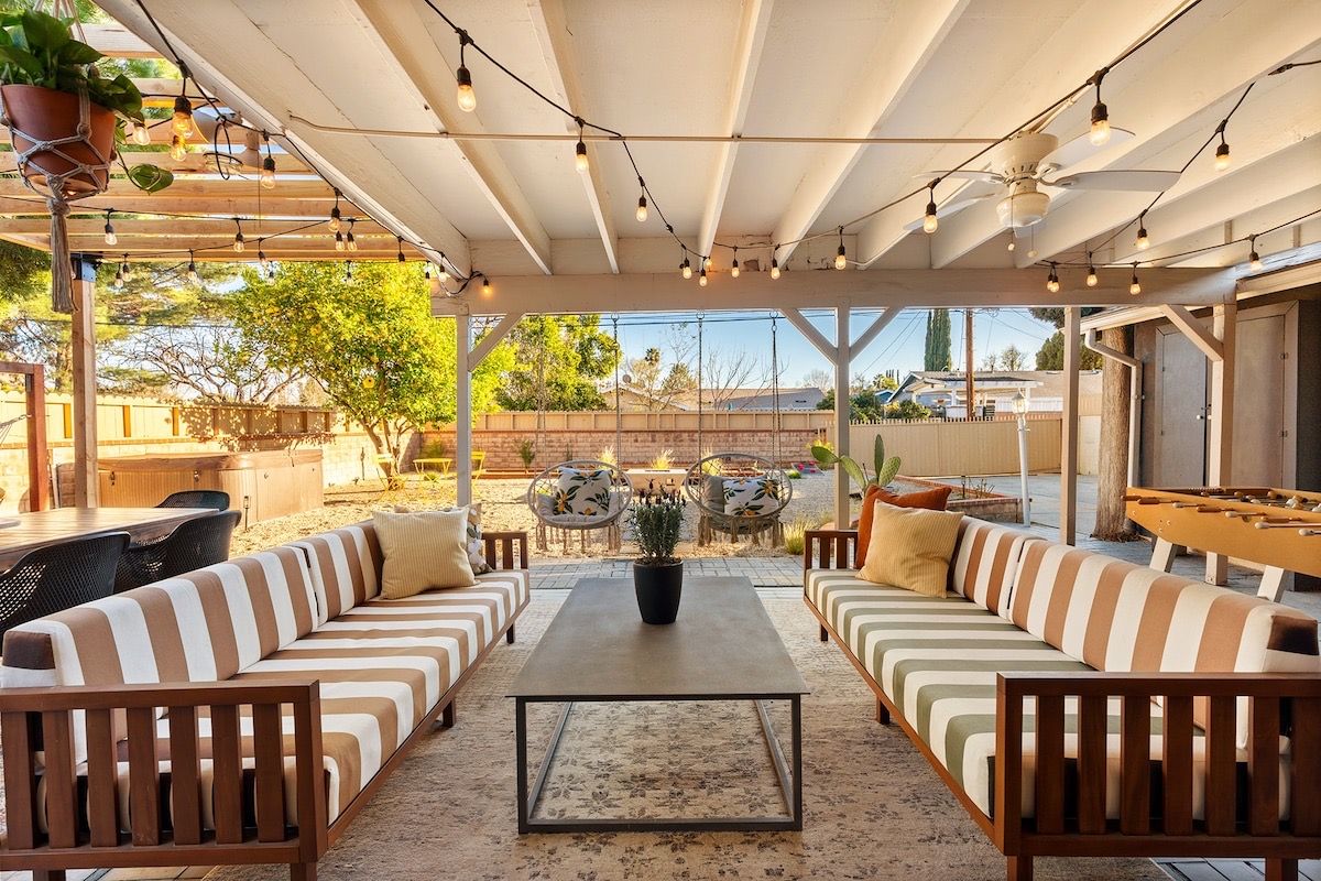 A covered patio with striped sofas and string lights at our Los Angeles house